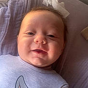 Maël participe au concours pour gagner de l'argent avec cette photo : baby, blanket, bunny_print, casual, child, clothing, cute, face, happy, head, indoors, infant, lying_down, person, portrait, purple, smiling, soft_light, toddler, young_child