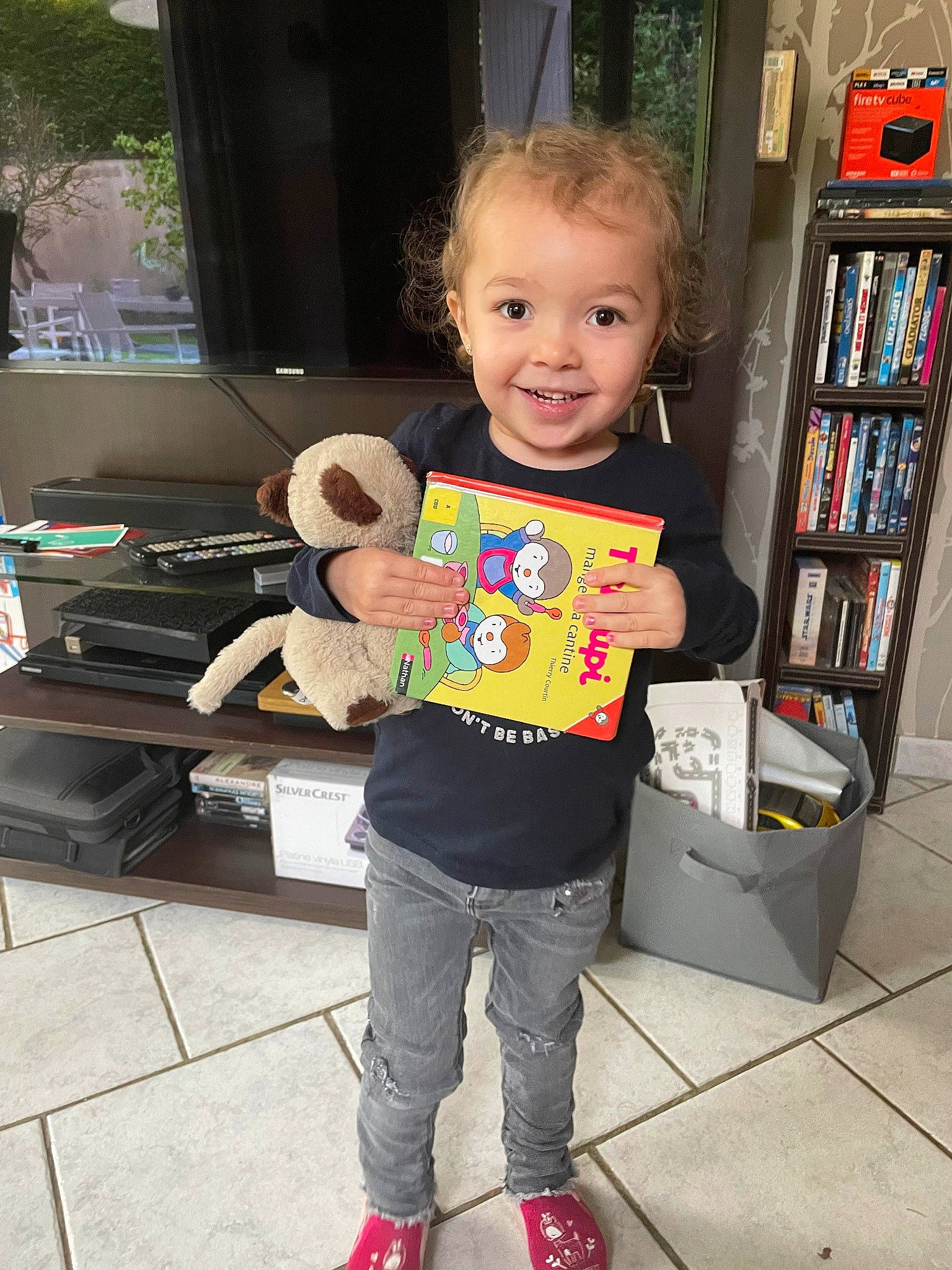 Lilou a rejoint le concours — aidez-le/la à gagner de superbes lots ! bookcase, box, cardboard, carton, child, floor, flooring, fun, joy, person, play, room, shelf, shelving, shipping_box, smile, snapshot, sock, standing, t_shirt