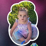 Aria joined the competition — help win amazing prizes! baby, background, button, child, colorful, cute, dress, face, frame, grass, greenery, outdoor, person, pigtails, portrait, sitting, social_media, text_overlay, toddler, toy