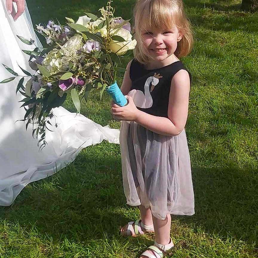 Mia a rejoint le concours — aidez-le/la à gagner de superbes lots ! backyard, clothing, dress, face, flower, flowerarrangement, flowerbouquet, formalwear, grass, head, lawn, nature, outdoors, person, petal, photography, plant, portrait, pottedplant, yard