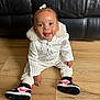 Khalesei is registered to the contest to win money with this photo: baby, black_leather_couch, bow, casual, child, curly_hair, cute, fashion, footwear, happy, indoor, knitted_clothing, person, portrait, seated, smiling, sneakers, toddler, white_outfit, wooden_floor