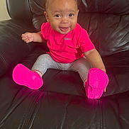 Khalesei is registered to the contest to win money with this photo: baby, child, smiling, pink_shoes, pink_bow, pink_shirt, leggings, leather_couch, happy, sitting, indoors, cute, young_child, person, footwear, small_hands, cheerful, portrait, casual, comfortable