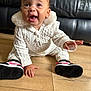 baby, child, couch, cute, expression, feet, floor, hand, happy, indoor, knitwear, leather, person, portrait, sitting, smiling, sneakers, white_clothing, wooden_floor, young_child