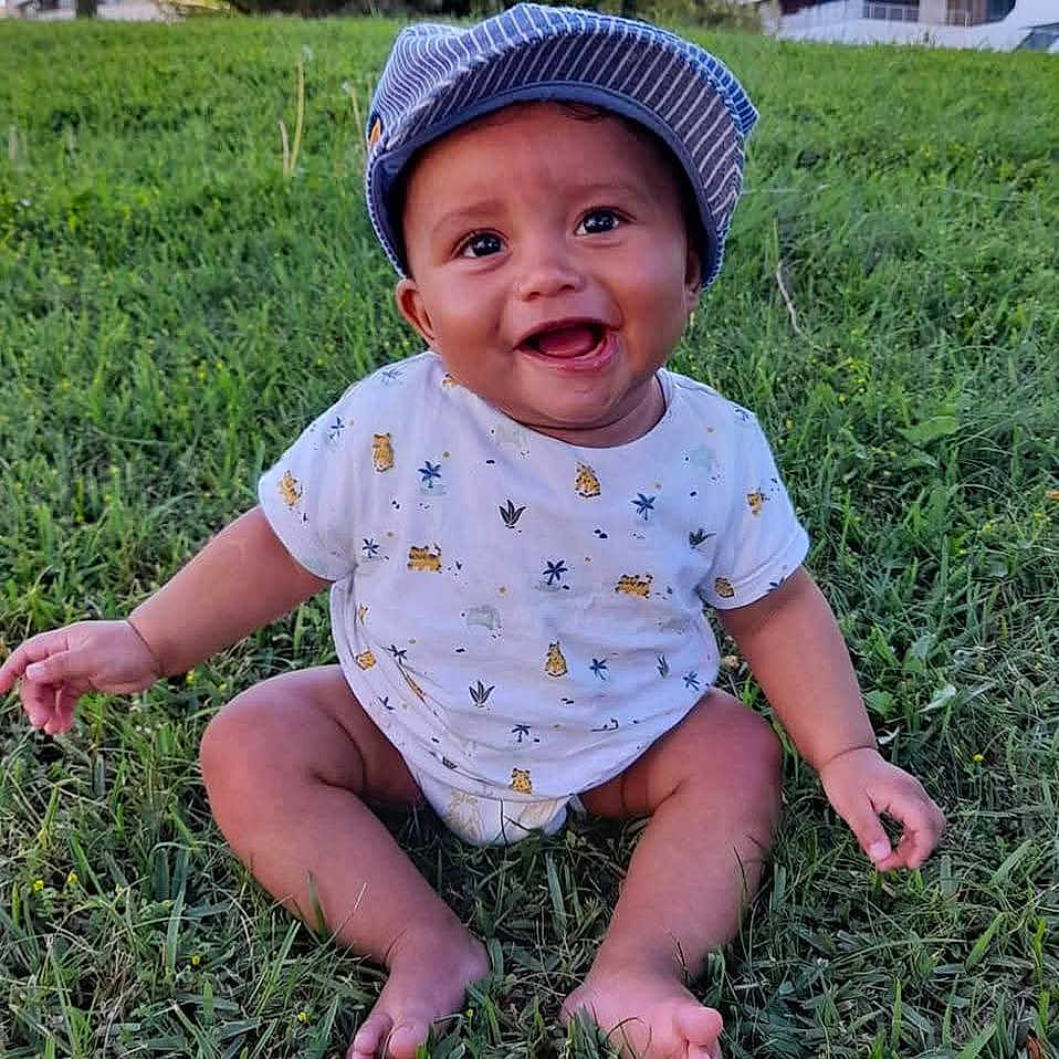 Matias Ramos participe au concours pour gagner de l'argent avec cette photo : baby, babylaughing, cap, clothing, face, grass, happy, hat, head, person, photography, plant, portrait, sitting, sleeve