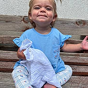 Adorabella is registered to the contest to win money with this photo: toddler, child, bench, blue_shirt, blanket, leggings, pigtails, smile, earrings, outdoor, wood, wall, happy, sitting, barefoot, person, cute, texture, young_child, portrait