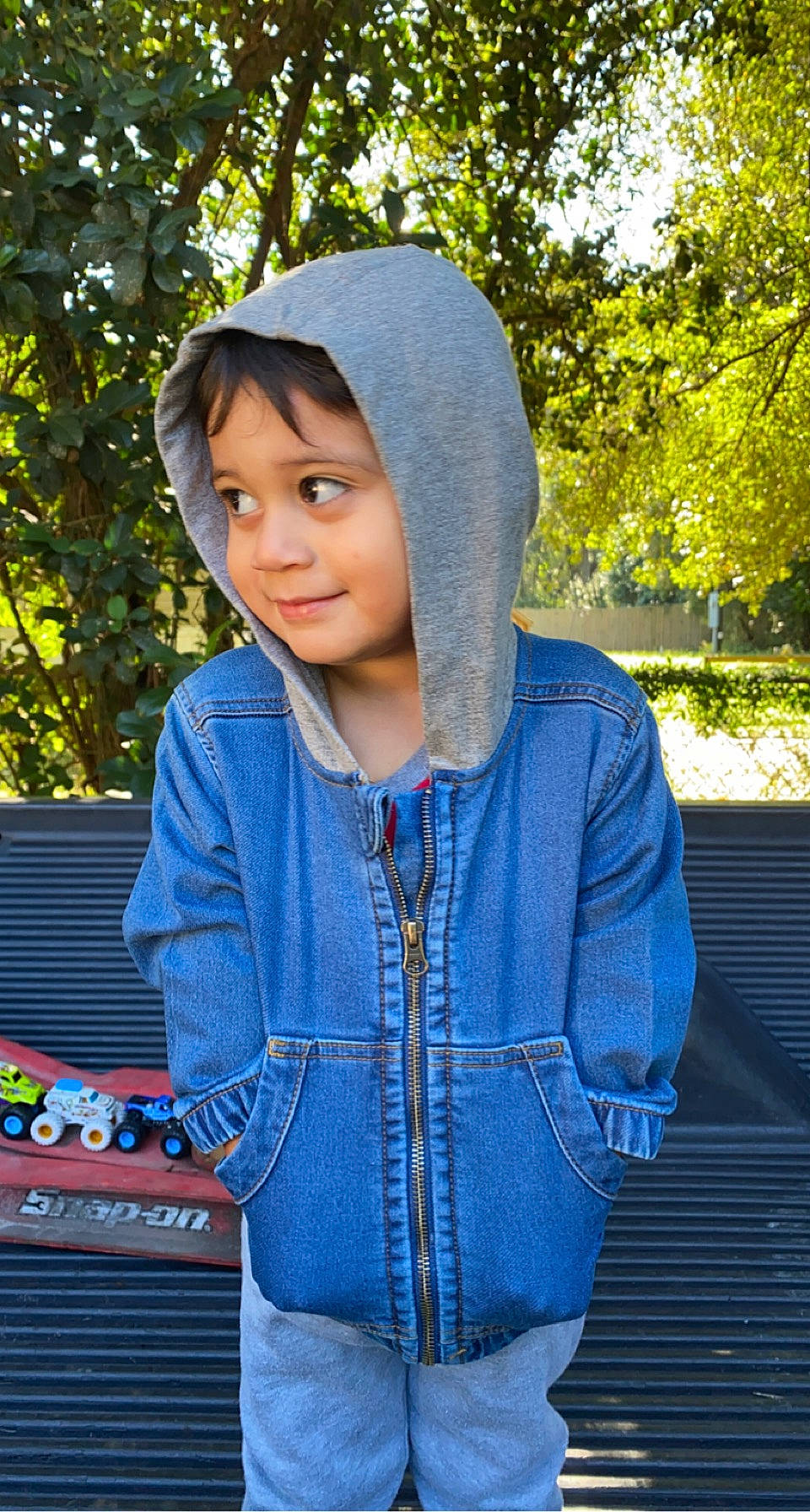 Eddie is registered to the contest to win money with this photo: cap, cool, denim, electric_blue, fashion_accessory, grass, happy, headwear, jewellery, knit_cap, lip, magenta, neck, outerwear, pattern, person, shoulder, sleeve, textile, tree