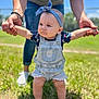 baby, child, denim_overalls, headband, barefoot, grass, outdoor, adult_hands, support, sunny, blue_sky, fence, person, standing, casual_clothing, summer, cute, determined, infant, nature