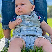 Autumn is registered to the contest to win money with this photo: baby, blue_headband, casual_clothing, child, cute, denim_overalls, grass, green_grass, headband, infant, jeans, legs, nature, outdoor, person, portrait, sneakers, summer, sunny, supporting_adult