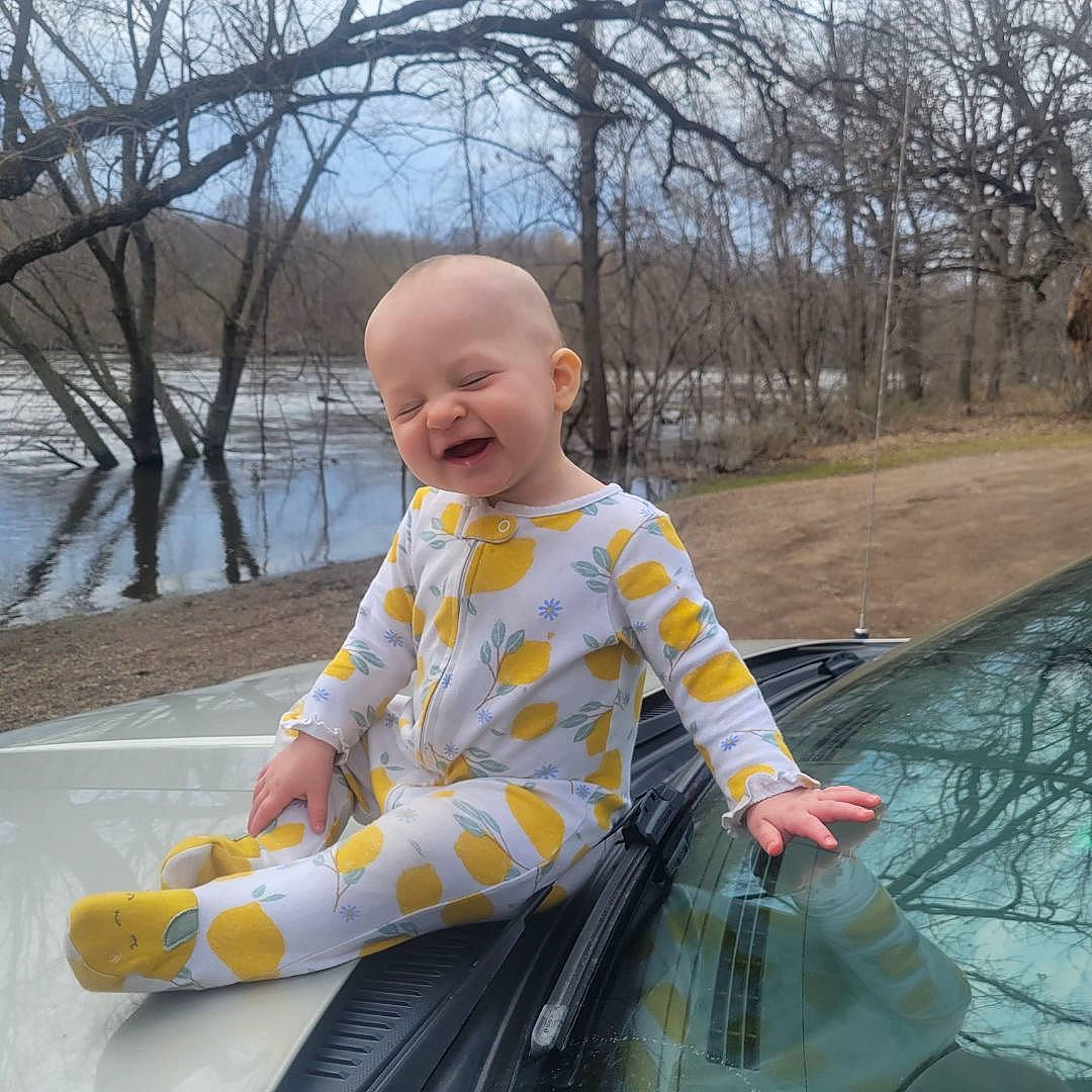 Azalea is registered to the contest to win money with this photo: baby, baby_toddler_clothing, child, fun, happy, lake, leisure, person, plant, recreation, sitting, sky, sleeve, smile, t_shirt, toddler, travel, tree, vehicle, water