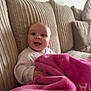 baby, blanket, couch, infant, smiling, happy, indoors, child, face, clothing, pink, cozy, seated, young, home, cute, portrait, soft, warm, comfort
