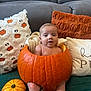 Tommy is registered to the contest to win money with this photo: baby, pumpkin, couch, pillow, blanket, fall, autumn, orange, cute, child, indoor, decor, seasonal, cozy, smile, person, infant, holiday, funny, home