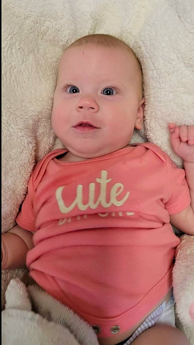 Henley joined the competition — help win amazing prizes! baby, baby_toddler_clothing, cheek, child, comfort, facial_expression, gesture, happy, linens, lip, magenta, peach, person, pink, product, skin, sleeve, smile, t_shirt, textile