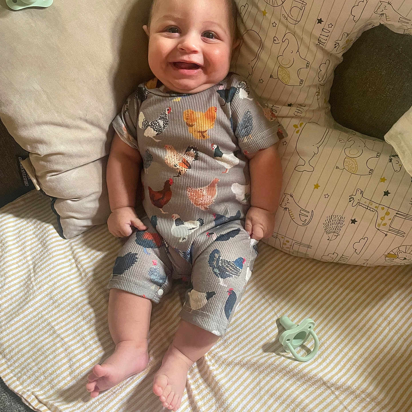 Robert joined the competition — help win amazing prizes! animal_print, baby, blanket, child, clothing, comfortable, cozy, cute, happy, indoors, infant, lying_down, pacifier, patterned_outfit, person, pillow, relaxing, smiling, soft_furnishing, striped_blanket