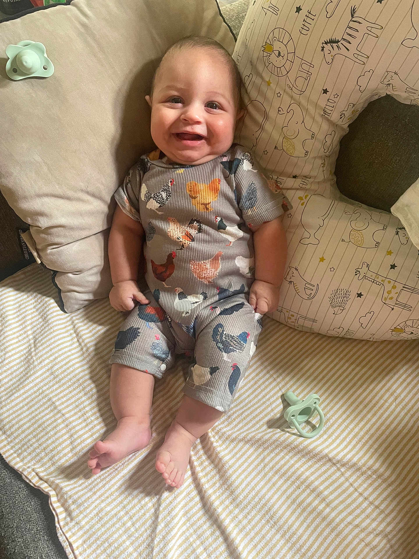 Robert joined the competition — help win amazing prizes! baby, smiling, infant, pillow, blanket, pacifier, cute, animal_print, striped_blanket, comfortable, indoors, clothing, patterned_outfit, happy, child, person, relaxing, soft_furnishing, lying_down, cozy