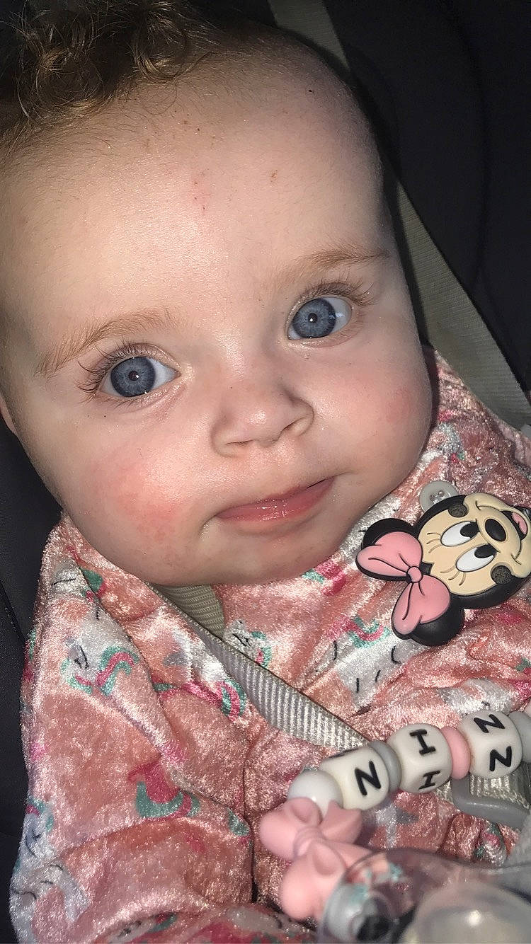 Nina participe au concours pour gagner de l'argent avec cette photo : baby, baby_toddler_clothing, cheek, chin, clothing, dress, ear, eyebrow, eyelash, facial_expression, finger, forehead, iris, lip, mouth, nose, organ, person, pink, skin