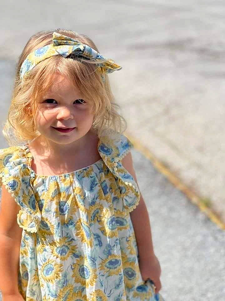 Brynn joined the competition — help win amazing prizes! baby_toddler_clothing, blond, brown_hair, clothing, day_dress, dress, electric_blue, eye, face, fun, grass, happy, head, headpiece, iris, pattern, person, plant, sleeve, smile