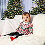 toddler, child, christmas_sweater, holiday, festive, couch, pillow, blanket, christmas_tree, lights, indoor, cozy, cute, portrait, smiling, red_socks, winter, decorations, home, celebration