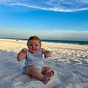 Colten joined the competition — help win amazing prizes! baby, child, sand, beach, ocean, sky, blue_sky, smile, happy, sitting, summer, vacation, sunlight, nature, outdoor, foot, waves, clouds, casual_clothing, cute