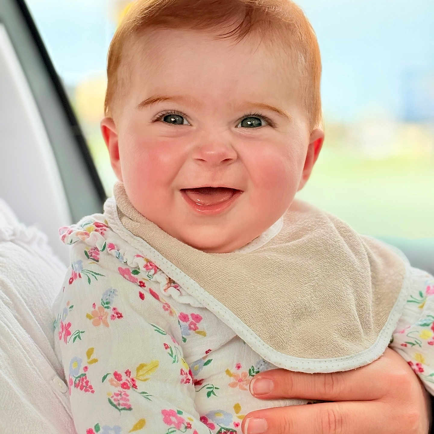 Jade a rejoint le concours — aidez-le/la à gagner de superbes lots ! adult_hand, baby, bib, child, cute, eyes, face, floral_clothing, hand, happy, holding, indoor, infant, mouth, person, portrait, ring, sitting, skin, smiling