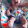 baby, child, smiling, happy, infant, baby_rocker, seat, colorful, patterned, animal_print, indoor, floor_tiles, foot, hand, person, cute, joyful, baby_clothing, strap, playful