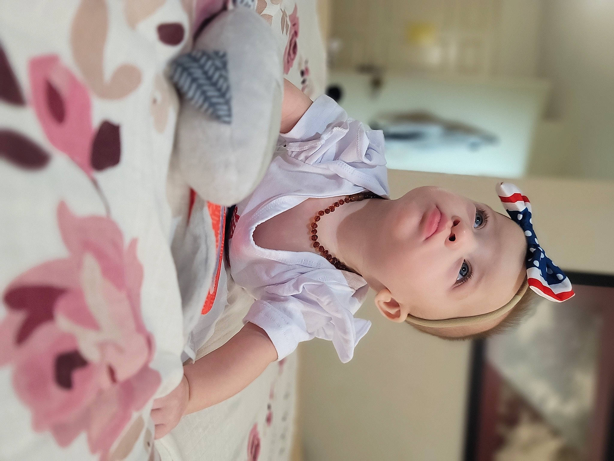 Oakley is registered to the contest to win money with this photo: arm, baby, baby_toddler_clothing, child, dress, eyelash, fashion_accessory, hand, happy, headwear, human_body, peach, person, petal, pink, plant, skin, sleeve, smile, textile