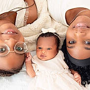 Kélyssia participe au concours pour gagner de l'argent avec cette photo : baby, child, woman, family, portrait, smiling, headband, glasses, black_hair, curly_hair, white_clothing, closeup, lying_down, skin, love, togetherness, indoors, happy, people, gentle