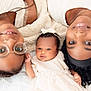 baby, child, woman, family, portrait, smiling, headband, glasses, black_hair, curly_hair, white_clothing, closeup, lying_down, skin, love, togetherness, indoors, happy, people, gentle