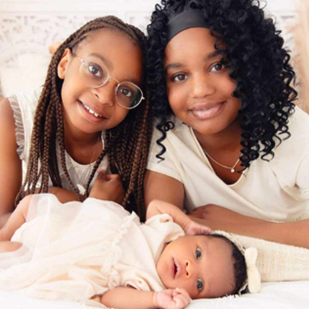 Kélyssia a rejoint le concours — aidez-le/la à gagner de superbes lots ! baby, bed, blanket, braids, candid, child, curly_hair, cute, family, glasses, happy, headband, indoors, people, portrait, skin_tone, smiling, soft_light, together, white_clothing