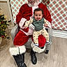 Daxyn Dereck is registered to the contest to win money with this photo: baby, beard, boots, chair, child, christmas, festive, flooring, glasses, happy, holiday, indoor, ornaments, person, plaid_wallpaper, red_suit, santa_claus, smile, tree, warm