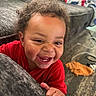 baby, blanket, carpet, child, closeup, couch, curly_hair, cute, face, fun, hand, happy, indoor, living_room, person, playful, portrait, red_shirt, smiling, toddler
