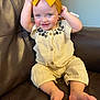 Kinsley is registered to the contest to win money with this photo: baby, child, smiling, headband, yellow, outfit, sitting, couch, leather, happy, blue_eyes, fists, indoor, cute, infant, person, portrait, playful, clothing, furniture