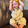 baby, child, smiling, sitting, couch, leather, headband, blue_eyes, clothing, happy, indoors, person, cute, infant, playful, portrait, hands, feet, fabric, furniture