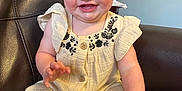 Kinsley is registered to the contest to win money with this photo: baby, child, smiling, blue_eyes, yellow_bow, headband, cream_outfit, floral_embroidery, sitting, couch, leather, indoor, happy, cute, infant, person, portrait, hand, foot, skin