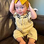 Kinsley joined the competition — help win amazing prizes! baby, child, infant, yellow_bow, headband, curious, sitting, leather_couch, indoor, cute, clothing, embroidered, feet, hands, face, blue_eyes, portrait, young, person, comfortable