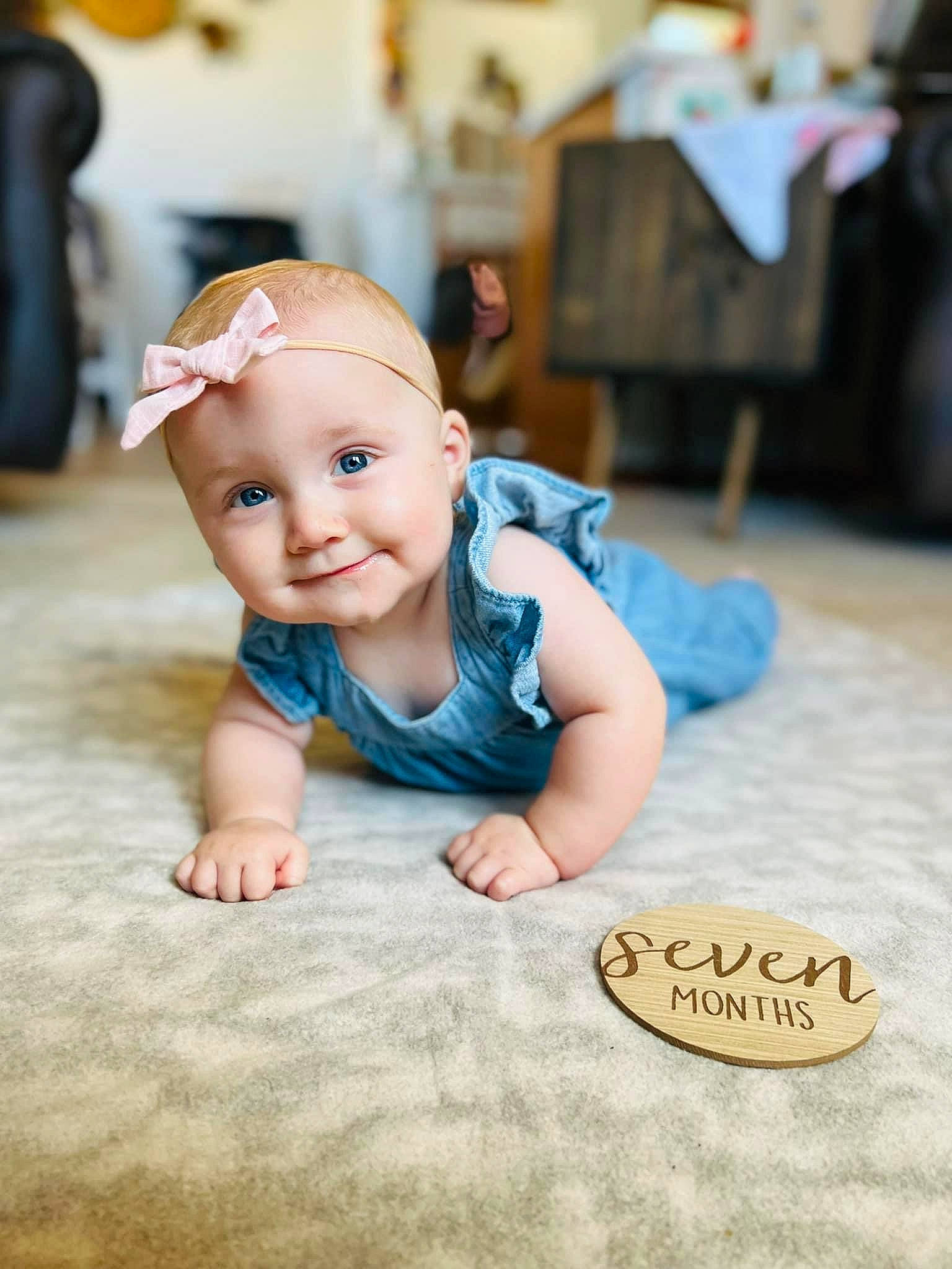 Eliza is registered to the contest to win money with this photo: baby, baby_toddler_clothing, cheek, child, finger, flash_photography, floor, flooring, fun, grass, happy, hardwood, joy, person, portrait_photography, room, sitting, skin, smile, textile