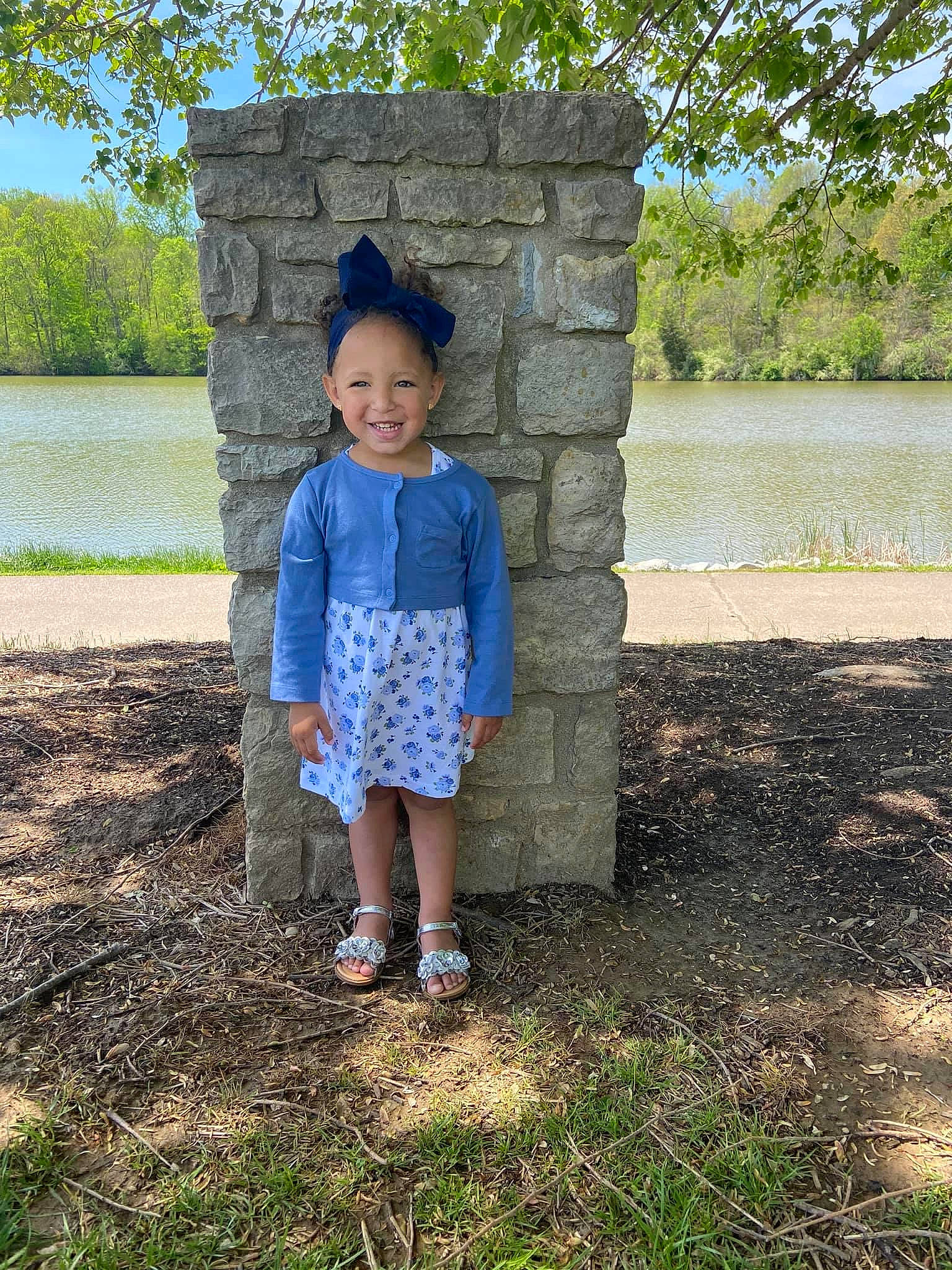 Kailynn is registered to the contest to win money with this photo: bank, blue, child, denim, dress, grass, jeans, joy, pattern, person, photography, plant, spring, standing, summer, toddler, tree, vacation, water