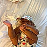 Jaylen joined the competition — help win amazing prizes! baby, child, infant, romper, hat, foot, hands, bed, sheet, animal_print, lying_down, cute, skin, person, indoors, sleepwear, white_background, baby_clothing, infant_pose, baby_hat