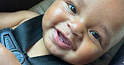 Jaylen is registered to the contest to win money with this photo: baby, smiling, face, child, car_seat, safety_harness, teeth, skin, closeup, happy, infant, toy, colorful, seat, seatbelt, cute, portrait, expression, human, baby_toy