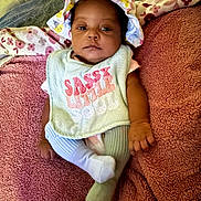 Khaza joined the competition — help win amazing prizes! baby, infant, hat, bib, clothing, sock, blanket, towel, person, face, expression, lying_down, indoors, cute, young_child, soft_texture, pink, pattern, comfort, portrait