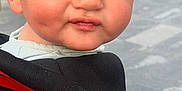Kaïs a rejoint le concours — aidez-le/la à gagner de superbes lots ! baby_carrier, black, blurred_background, child, clothing, cute, daylight, expression, face, hair, outdoor, people, person, pucker, red, side_view, skin, toddler, urban, young_child