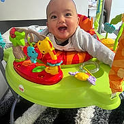 Kaïs a rejoint le concours — aidez-le/la à gagner de superbes lots ! activity_jumper, baby, carpet, child, clothing, colorful, cute, floor, furniture, happy, head, indoor, infant, living_room, person, plastic, playful, seat, smiling, toys