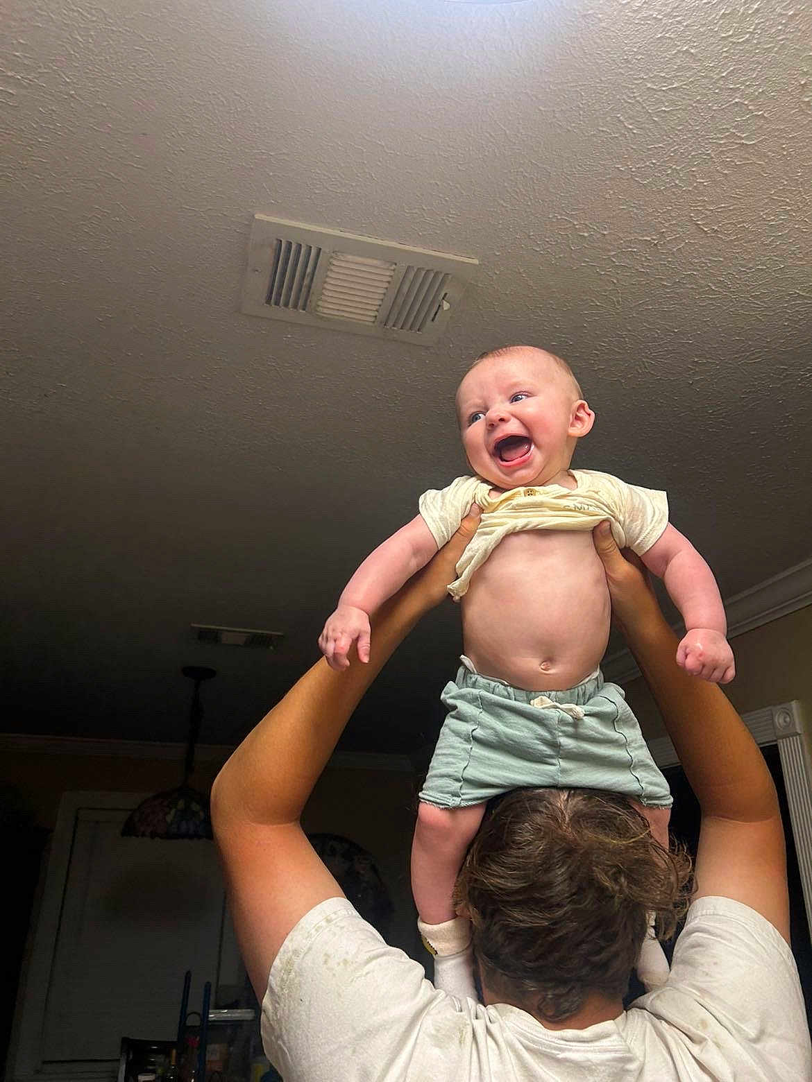 River joined the competition — help win amazing prizes! baby, child, person, indoor, smiling, happy, holding, arms, shirt, shorts, ceiling, vent, light, hair, skin, adult, window, room, playful, joy