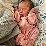 baby, newborn, sleeping, pink_onesie, giraffe_print, blanket, soft_texture, infant, cute, cozy, child, peaceful, resting, baby_bedding, patterned, toddler, nursery, indoors, person, sleep