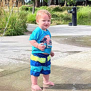 Sylas is registered to the contest to win money with this photo: toddler, child, water_park, splash_pad, water_spray, summer, outdoor, play, barefoot, shorts, tshirt, grass, plants, sidewalk, fun, sunny, daytime, nature, happy, cute
