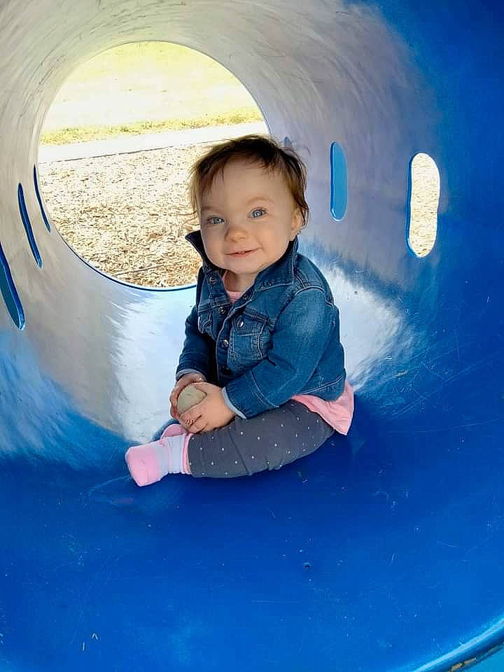 Molly is registered to the contest to win money with this photo: azure, baby_toddler_clothing, blue, child, chute, circle, electric_blue, eye, flash_photography, fun, hair, happy, hood, joy, leisure, outdoor_play_equipment, person, play, playground, recreation
