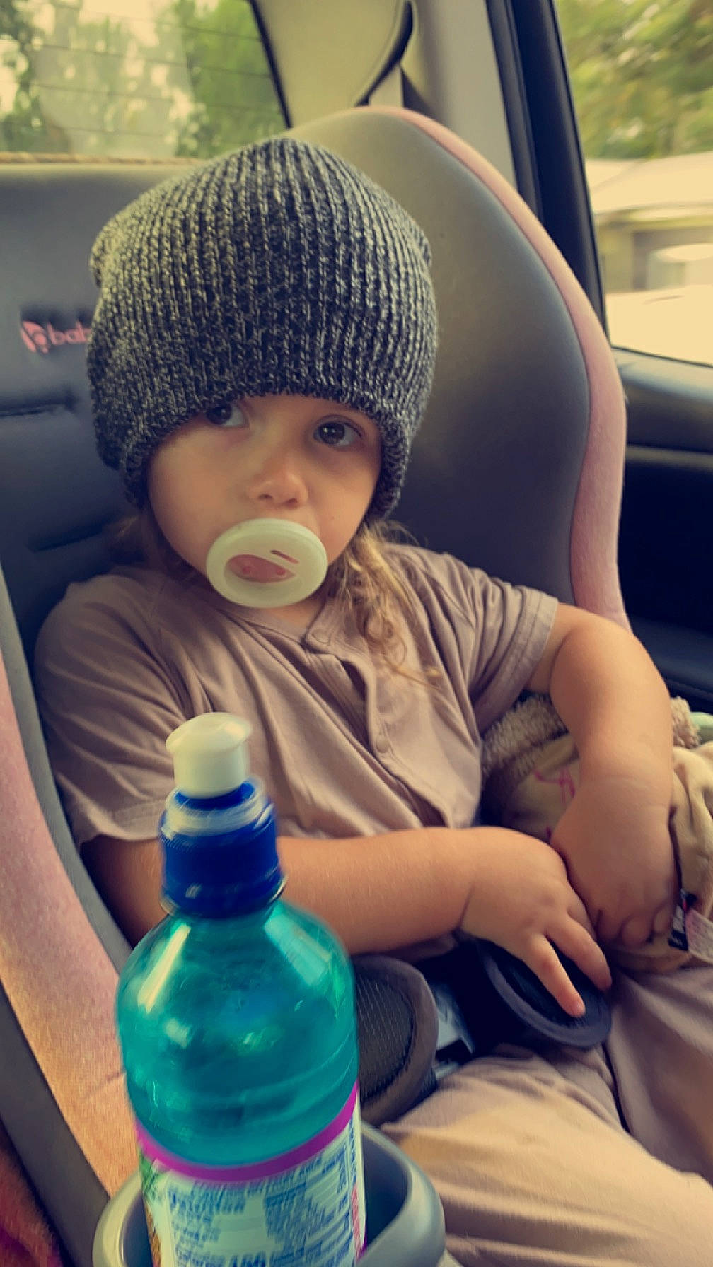 Brynlee is registered to the contest to win money with this photo: arm, beauty, blue, bottle, cap, cool, drinkware, electric_blue, face, finger, headwear, light, morning, organ, person, photograph, plastic_bottle, skin, toddler, vehicle_door