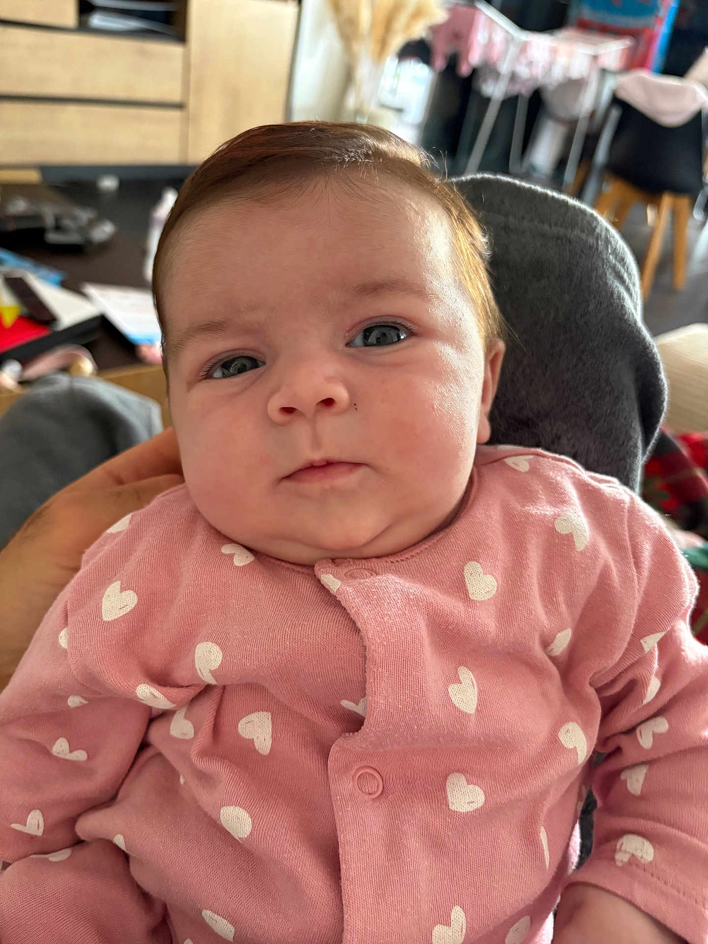 Giulia a rejoint le concours — aidez-le/la à gagner de superbes lots ! baby, infant, pink_clothing, heart_pattern, face, blue_eyes, indoor, hand, seated, closeup, person, cute, soft_lighting, furniture, background_blur, newborn, child, portrait, cozy, expression