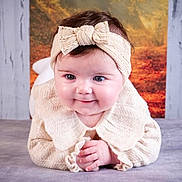 Giulia a rejoint le concours — aidez-le/la à gagner de superbes lots ! autumn, baby, background, blue_eyes, bow, child, cozy, cute, face, hands, headband, indoors, infant, knitwear, lying_down, portrait, smile, sweater, tree_trunk, tummy