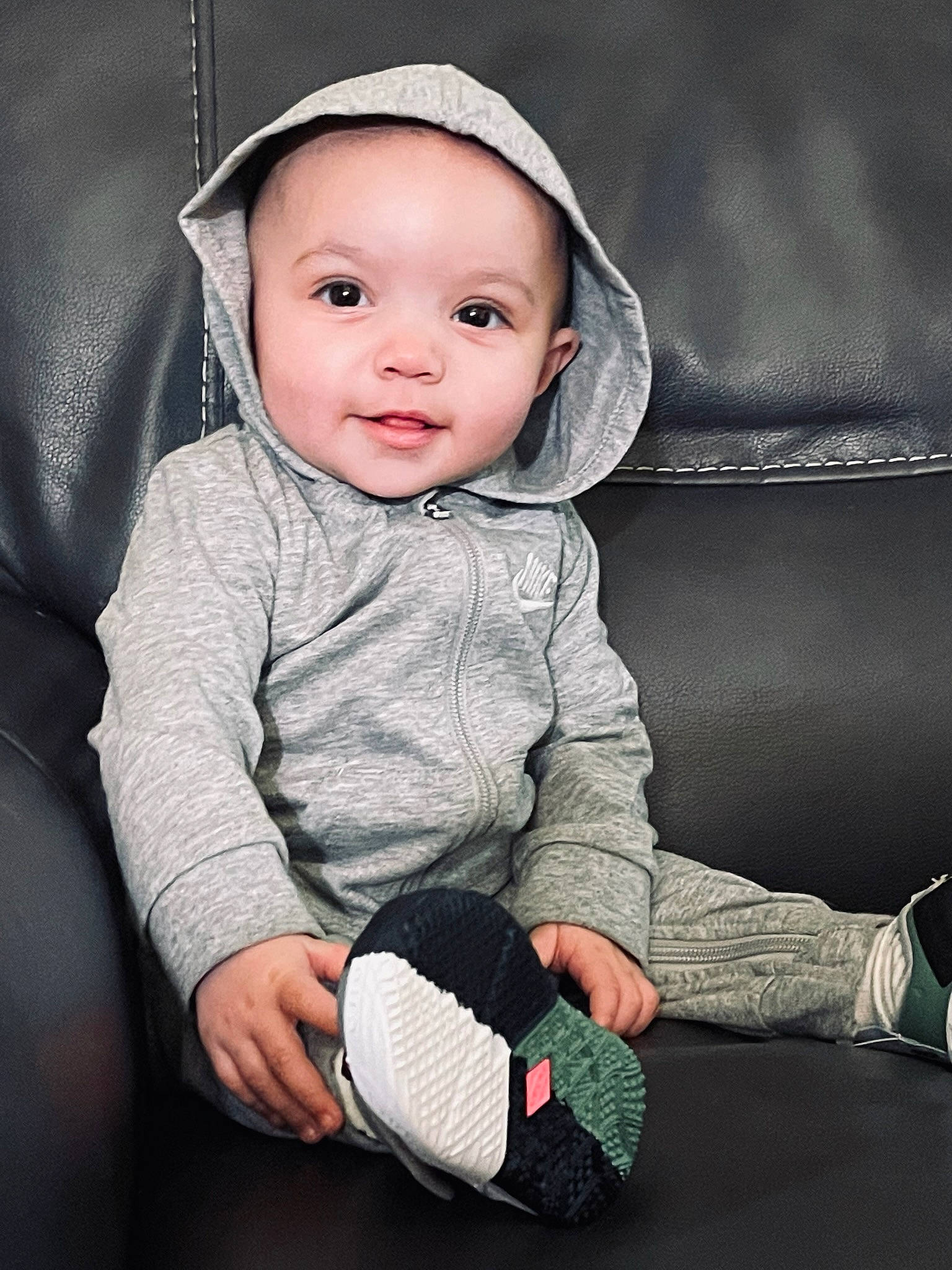 Nova is registered to the contest to win money with this photo: arm, baby, baby_toddler_clothing, black, cheek, comfort, eye, face, flash_photography, happy, head, headgear, headwear, iris, lip, nose, person, sitting, skin, sleeve