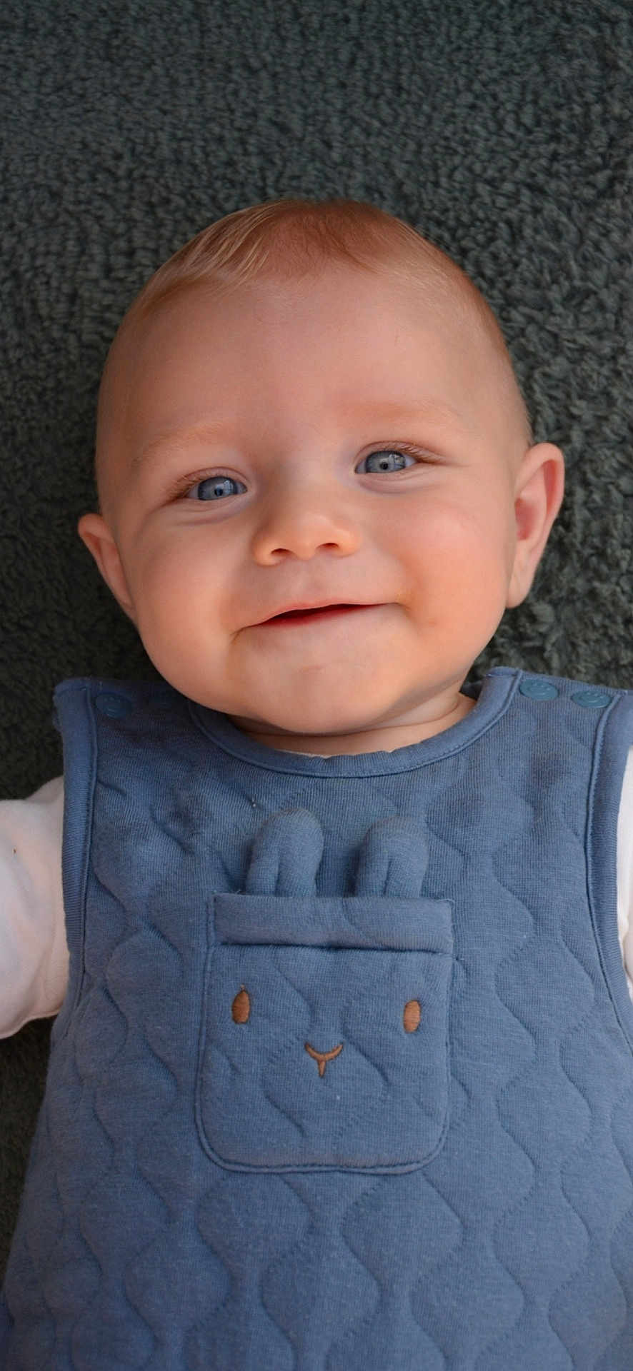 Malo participe au concours pour gagner de l'argent avec cette photo : baby, child, smiling, blue_eyes, face, infant, clothing, quilted, bunny_design, pocket, cute, lying_down, blanket, textured, portrait, young_child, apparel, happy, indoor, head